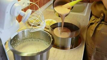 4K video Resolution. Stage of making delicious homemade mousse cake Triple chocolate. Pouring of whipped cream with melted chocolate. Chef pastry, confectioner preparing sweet dessert for birthday