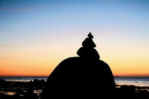 Roca pirámide en el báltico mar con un ver de el mar a puesta de sol y azul hora foto