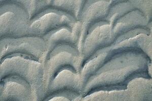 Structure in the sand made by waves. View on the ground at low tide. Nature photo