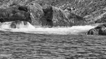 Norway on the fjord, spray on rocks in black and white. Water splashing on rocks photo