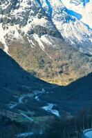 View between mountains in Norway, through which a road leads. Snow on the mountains photo