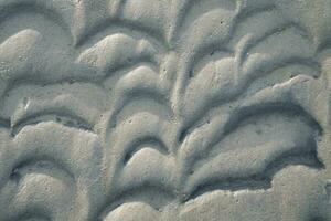 Structure in the sand made by waves. View on the ground at low tide. Nature photo