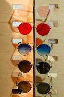 large selection of sunglasses and glasses on a stand photo