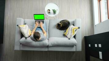 Overhead shot of woman using laptop with green mock-up screen video