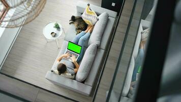 Overhead shot of woman using laptop with green mock-up screen video