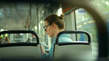 Publique transport. femme dans tram en utilisant téléphone intelligent, retour voir. video