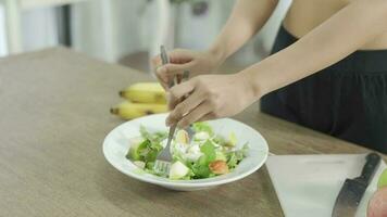 jovem mulher fazer saudável salada dentro a cozinha de ela mesma. video