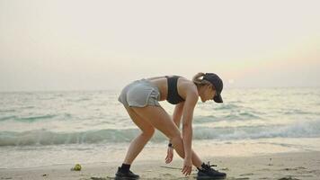 joven mujer en traje practicando yoga en el playa encima mar a increíble amanecer. aptitud física, deporte, yoga y sano estilo de vida concepto. video