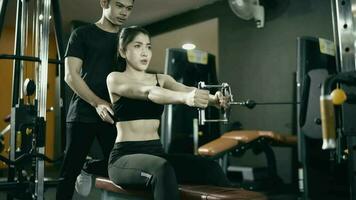 woman wearing workout clothes There are male trainers to exercise with exercise machines. video