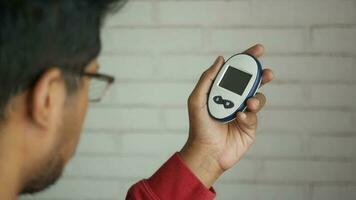 Rückseite Aussicht von des Mannes Hand halten ein Glucose Meter video