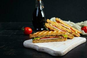 Club sandwich with ham, tomato, green and cheese. Grilled panini photo