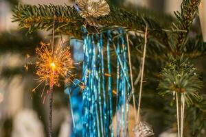 blue tinsel and a burning sparkler with lot of sparks at christmas photo