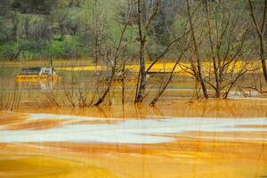 A lake contaminated with toxic waste in the western mountains of Romania. Nature pollution from copper mine. Ecological catastrophe or Environmental disaster photo