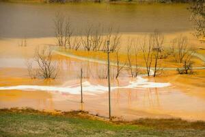 A lake contaminated with toxic waste in the western mountains of Romania. Nature pollution from copper mine. Ecological catastrophe or Environmental disaster photo