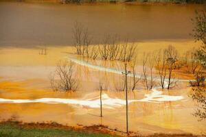 A lake contaminated with toxic waste in the western mountains of Romania. Nature pollution from copper mine. Ecological catastrophe or Environmental disaster photo