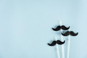 Curly mustaches on colorful background. Fake mustache. Top view photo