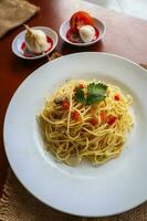aglio e olio. Italian Pasta Spaghetti, aglio olio e pepperoni ,spaghetti with garlics, olive oil and chilli peppers on plate on table photo