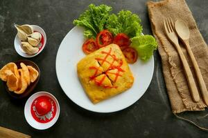 nasi goreng pattaya or Pattaya Fried Rice, Stuffed Omelette Fried Rice. Southeast Asian dish made by covering or wrapping chicken fried rice, in thin fried egg or omelette photo