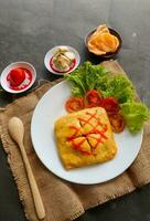 nasi goreng pattaya or Pattaya Fried Rice, Stuffed Omelette Fried Rice. Southeast Asian dish made by covering or wrapping chicken fried rice, in thin fried egg or omelette photo