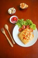 nasi goreng pattaya or Pattaya Fried Rice, Stuffed Omelette Fried Rice. Southeast Asian dish made by covering or wrapping chicken fried rice, in thin fried egg or omelette photo