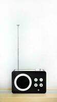 Vertical image, Retro style vintage transistor radio receiver, nostalgia, tuning function with AM and FM frequency station, on wooden counter and white background photo