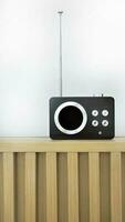 Vertical image, Retro style vintage transistor radio receiver, nostalgia, tuning function with AM and FM frequency station, on wooden counter and white background photo