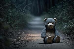 Plush lonely abandoned bear toy on path in dark forest, outdoors. Concept of loss of child, children's abuse, end of childhood. photo