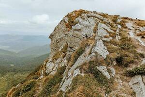 a rock made of stone in the mountains on the background of a panoramic sky photo