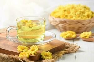 Chrysanthemum tea and Chrysanthemum flower in basket on white wood background. photo