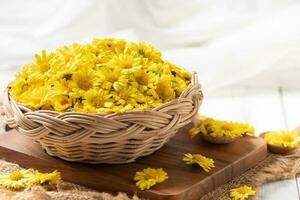 Fresh chrysanthemum flower in basket on a wooden background. photo