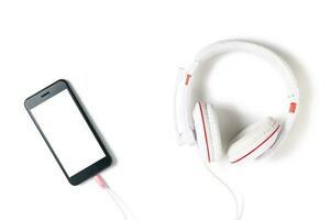 blanco auriculares y móvil teléfono con blanco pantalla aislado foto
