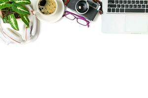 top view of office desk table with coffee cup, laptop and retro camera isolated photo