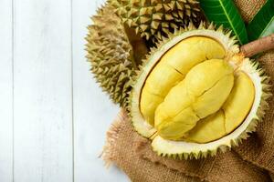 Fresh durian Kan yao or Durio zibthinus Murray on sack and old wood background, photo