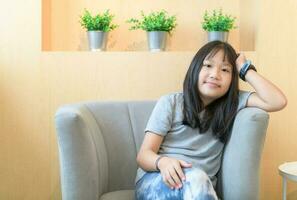 Cute girl sitting on the sofa in the living room, photo