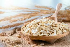Half raw cashews nuts in bamboo basket on sack, photo