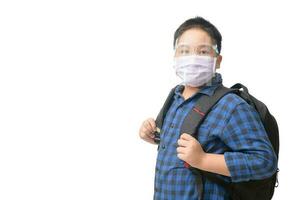 asiático chico estudiante vestir cara proteger y máscara lleva colegio bolso aislado foto