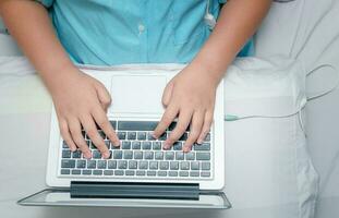 child working homework with laptop on bed. photo