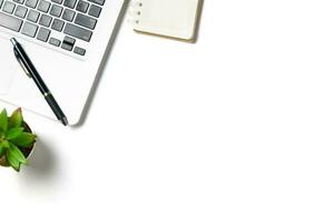 White office desk table with laptop computer and blank notebook isolated on white background. photo