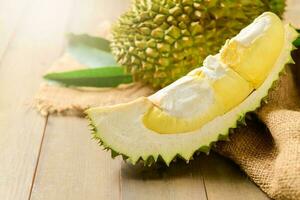 Fresh cut durian monthong on sack and old wood background, photo