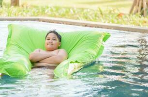 fat boy play air mattress on swimming pool, photo