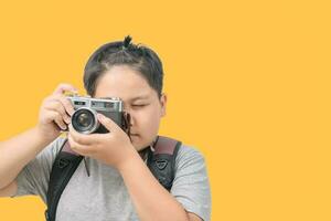 Obese boy traveler taking a picture with a vintage camera photo