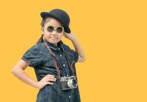 linda pequeño niña vistiendo sombrero sonriente y participación mochila a viaje foto