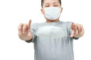 Fat boy holding surgical medical mask in hands isolated photo