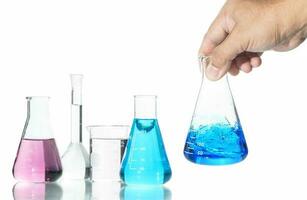 hand scientist shaking Erlenmeyer flask with blue liquid isolated on white photo