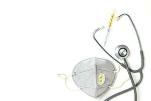 Medical mask with stethoscope and thermometer isolated photo