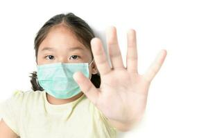 Asia girl wearing mask for protect pm2.5 and show stop hands gesture for stop corona virus photo