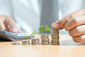 Businessman put Coin to Highest Stack Of Coins, photo