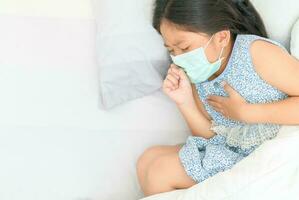 Asian girl wear hygienic mask iscoughing and chest pain photo