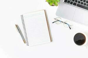 White office desk table Blank notebook with laptop computer photo