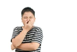 Obese boy holding his nose because of a bad smell photo